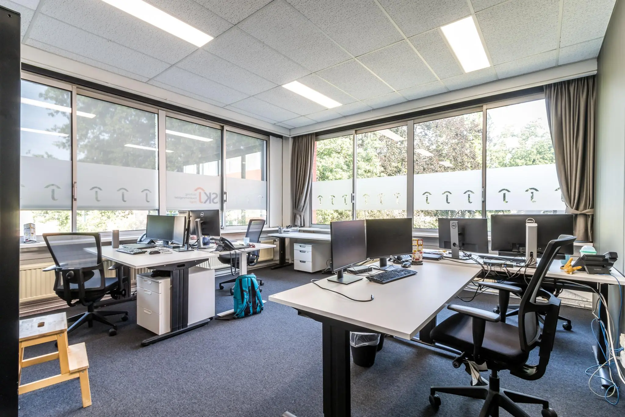 Modern kantoor met meerdere werkplekken en grote ramen aan de Jan van Eycklaan.